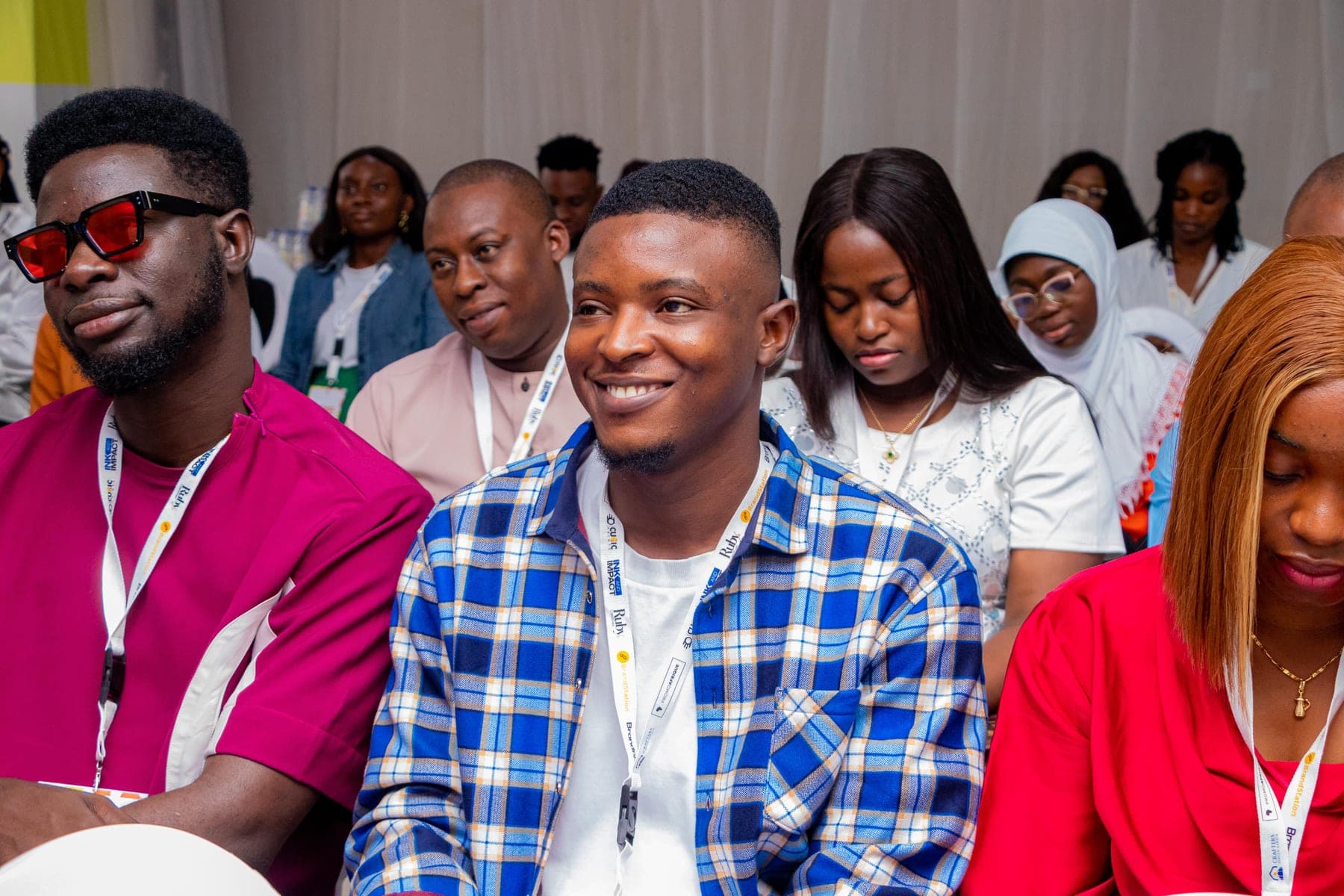 Members listening together during a session at Ink & Impact