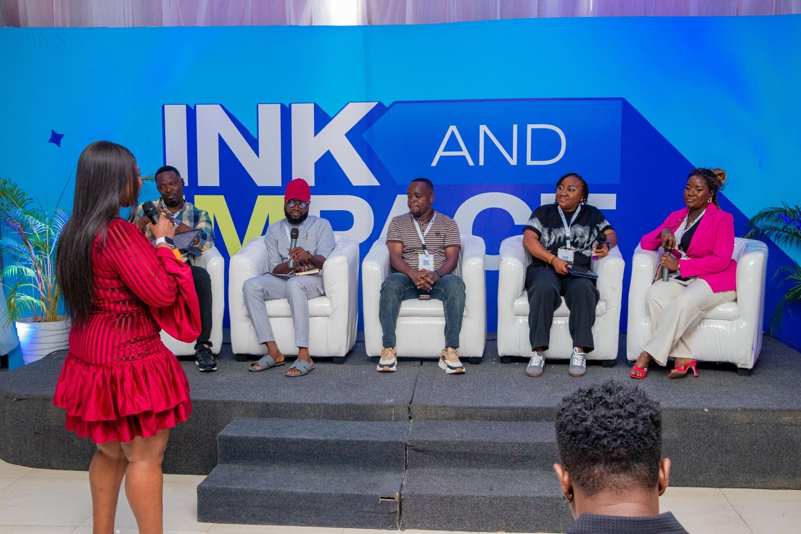 A panel seated on stage at Ink & Impact 1.0