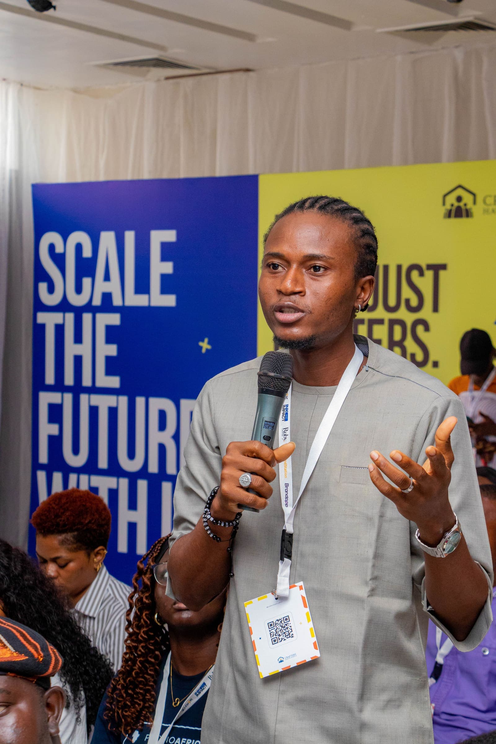 A member speaking at Ink & Impact in front of the Scale the Future wall